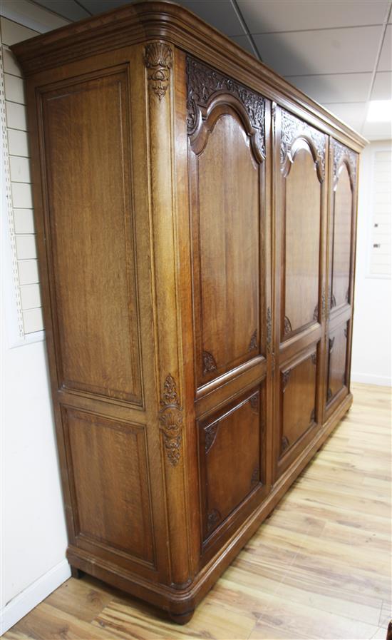 A large early 20th century French oak triple armoire, W.8ft 8in.